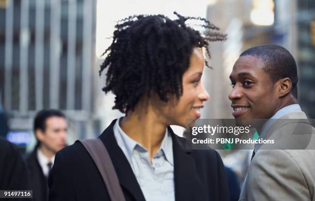 african american businesswoman smiling at businessman on street - destiny photos et images de collection