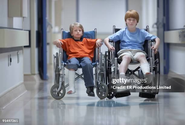 two boys with casts in wheelchairs - broken friendship stock pictures, royalty-free photos & images