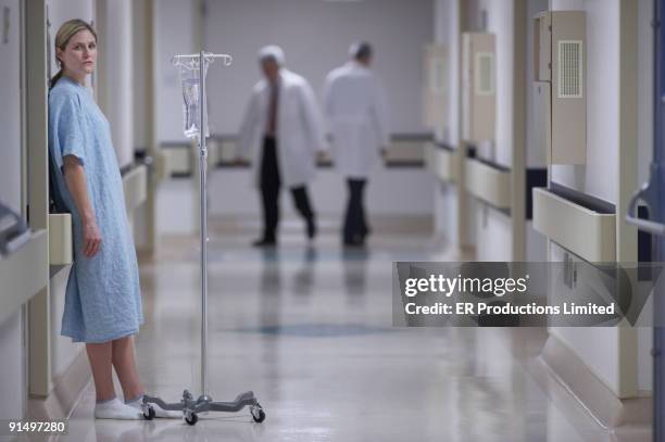 woman in hospital gown with iv - hospital gown stock-fotos und bilder