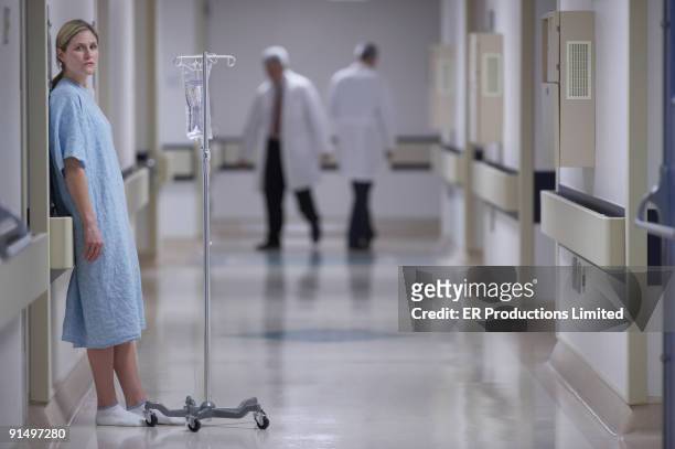 woman in hospital gown with iv - incidental people stock pictures, royalty-free photos & images