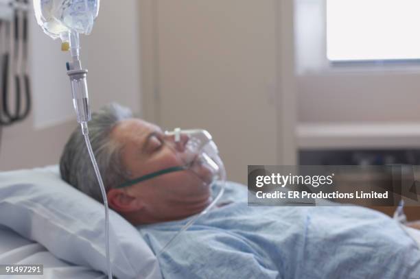 man laying in hospital bed - medical oxygen equipment stock pictures, royalty-free photos & images