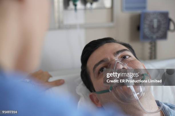 hispanic man wearing oxygen mask in hospital - medical oxygen equipment fotografías e imágenes de stock