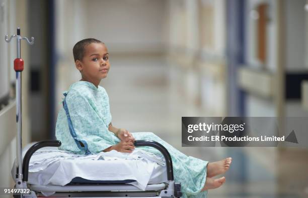 mixed race boy in hospital gown - hospital gown stock-fotos und bilder