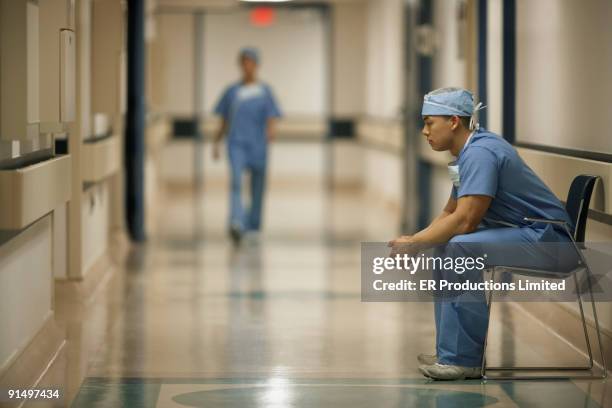 asian male medical professional sitting in chair - doctor profile view stock pictures, royalty-free photos & images