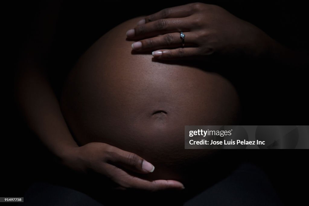 Close up of mixed race woman's pregnant stomach
