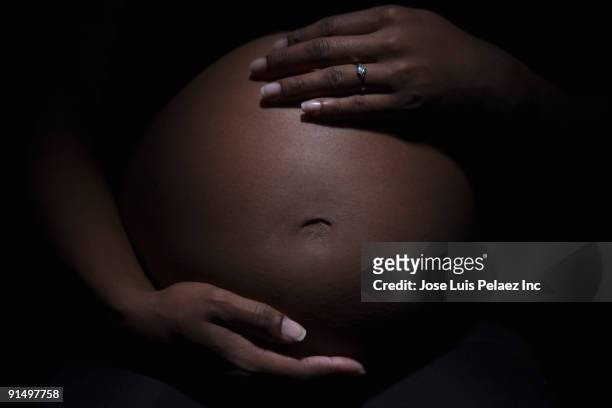 close up of mixed race woman's pregnant stomach - stomach stock pictures, royalty-free photos & images