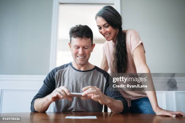 mature couple photographing check for remote deposit - cheque deposit stock pictures, royalty-free photos & images