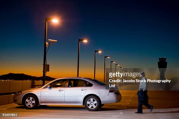 african businessman walking to car in parking lot - stationnement photos et images de collection
