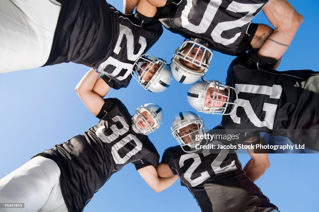 Football players in huddle