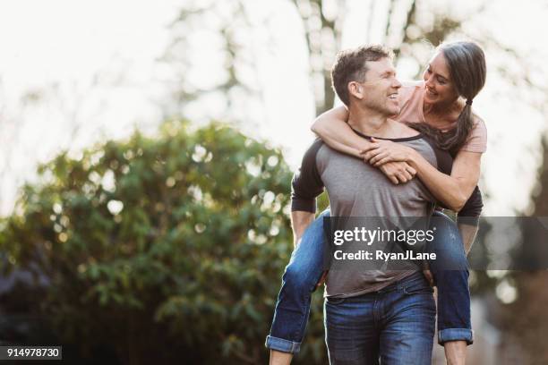 loving mature couple playing outdoors - healthy older couple stock pictures, royalty-free photos & images