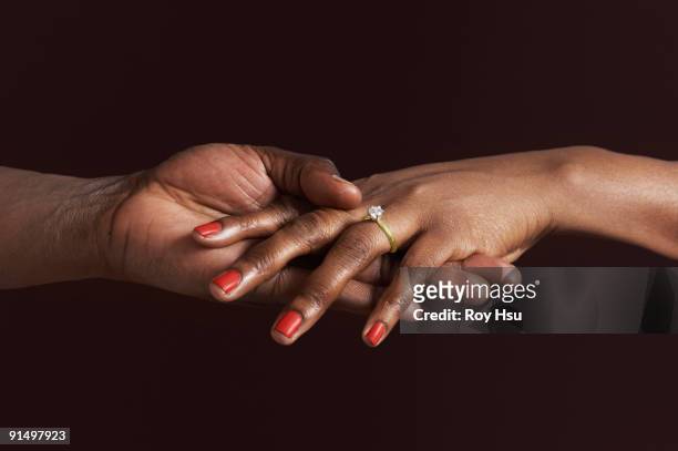 african woman with engagement ring holding fiancee's hand - 結婚戒指 個照片及圖片檔