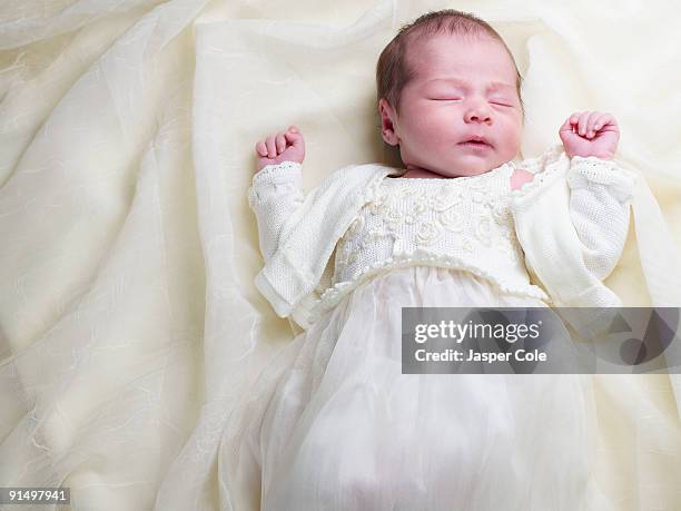 close up of mixed race newborn baby in christening gown - christening gown stock-fotos und bilder