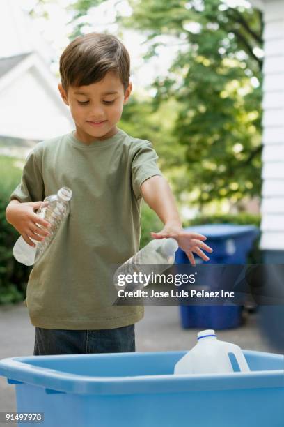 boy tossing recyclable bottles into bin - bottle bank stock pictures, royalty-free photos & images