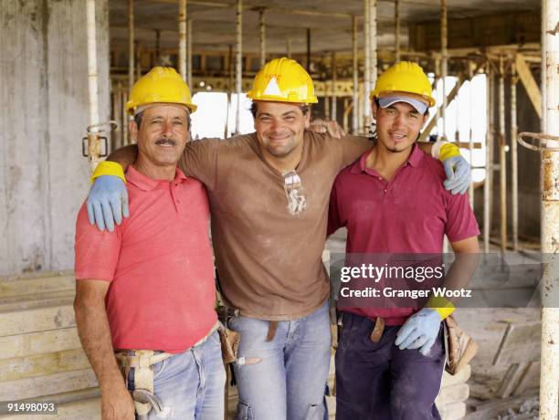 hispanic workers hugging on construction site - first mate stock pictures, royalty-free photos & images