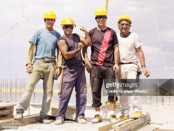 hispanic workers standing on construction site - macho stockfoto's en -beelden