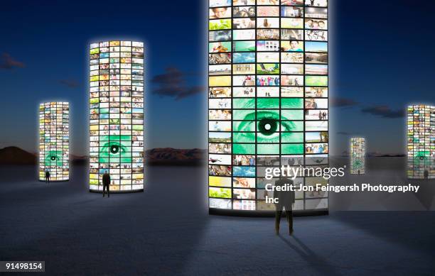 businessmen standing next to pillars of television screens - commercial building people stockfoto's en -beelden