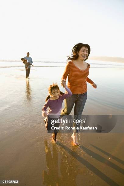 hispanic family playing on beach - hispanic man on beach stock-fotos und bilder