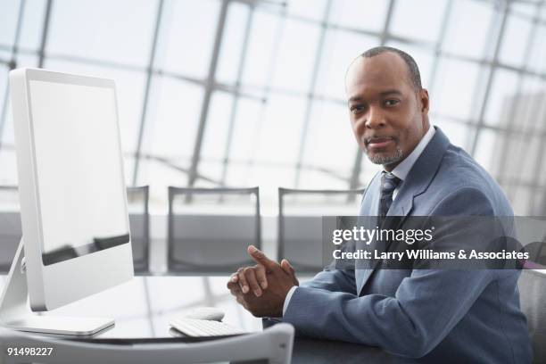 african businessman sitting at conference table - leitende person stock-fotos und bilder