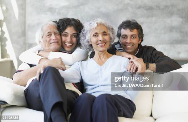 hispanic family smiling on sofa - daughter in law stock pictures, royalty-free photos & images