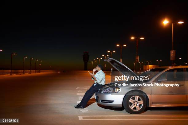 african businessman having car trouble in parking lot - vehicle breakdown photos et images de collection