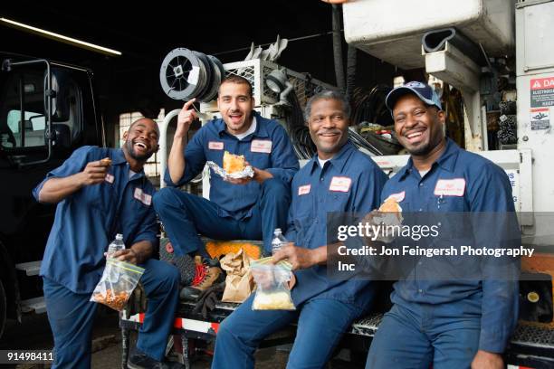 mechanics eating lunch together - mechanic uniform stock pictures, royalty-free photos & images