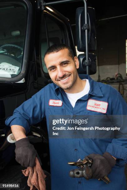middle eastern mechanic in repair shop - funktionskleidung stock-fotos und bilder