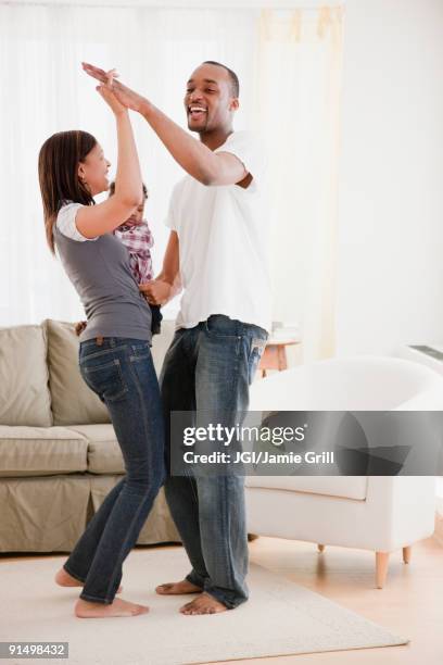 african couple and baby dancing in living room - mom flirting stockfoto's en -beelden