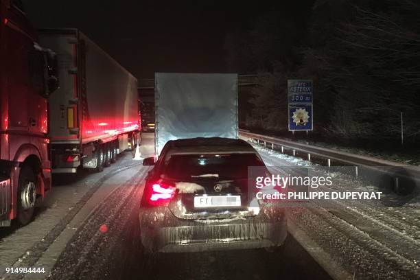 Vehicles travel through fresh snowfall on the A1 autoroute near Senlis in the Oise Department some 30kms north-east of Paris on February 6, 2018.
