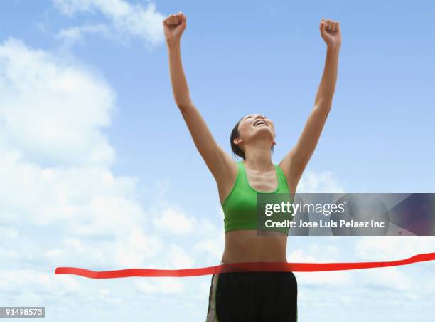 chinese runner crossing finish line - runner winning stock pictures, royalty-free photos & images