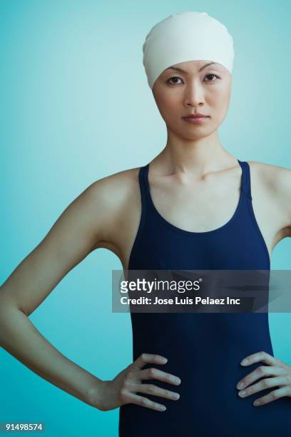 serious chinese woman in bathing suit and swimming cap - schwimmer freisteller stock-fotos und bilder