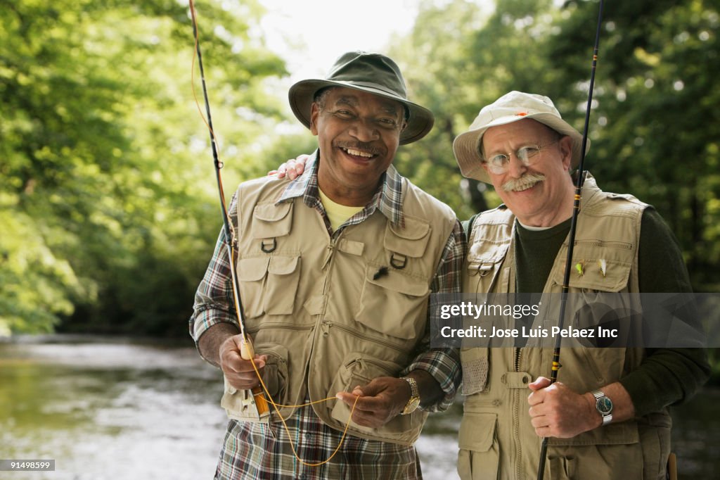 Men in fishing vests holding fishing rods