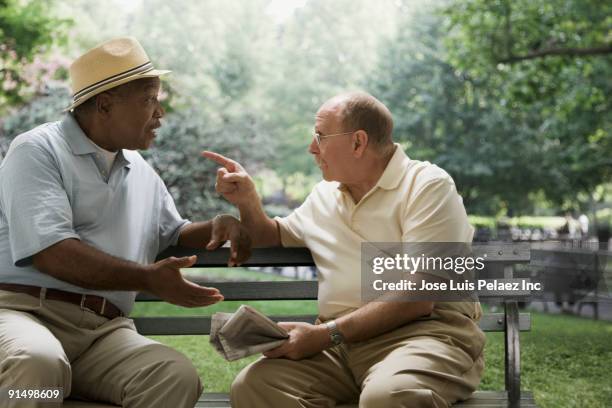 men arguing on park bench - friends argue fotografías e imágenes de stock