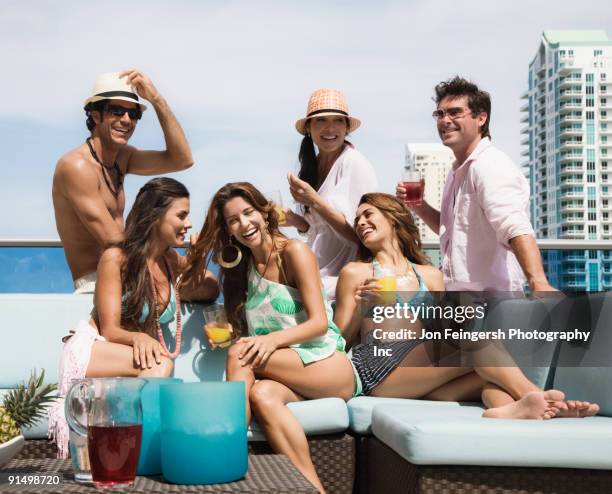hispanic men and women partying on rooftop - miami party stock pictures, royalty-free photos & images