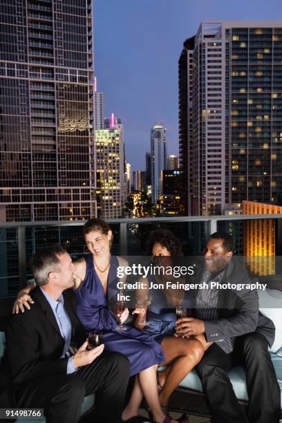 couples drinking cocktails on urban balcony - double date stock pictures, royalty-free photos & images