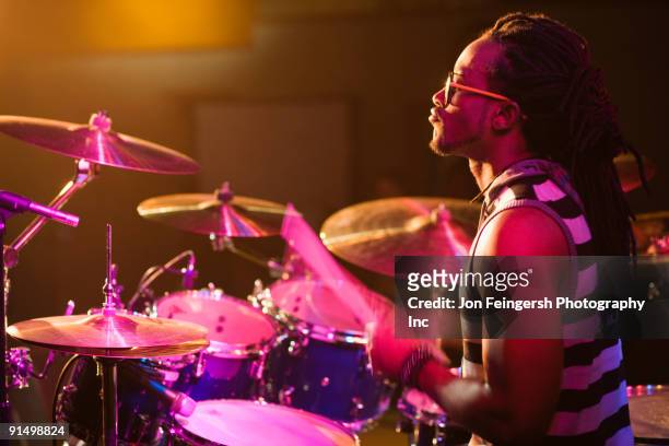african man playing drums onstage - drummer stockfoto's en -beelden