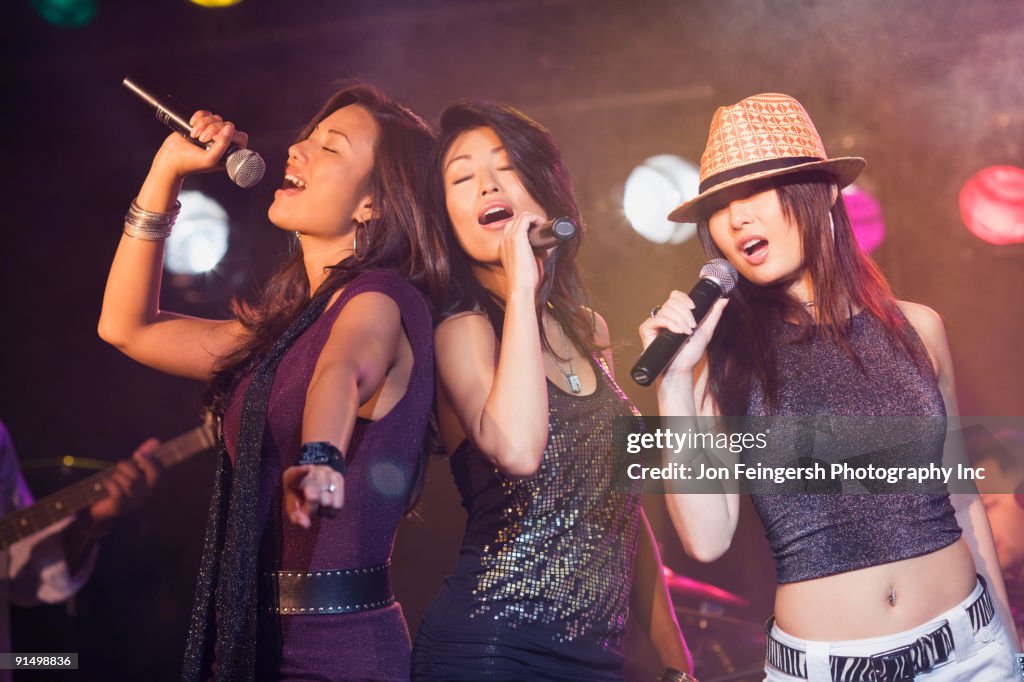 Asian women singing onstage