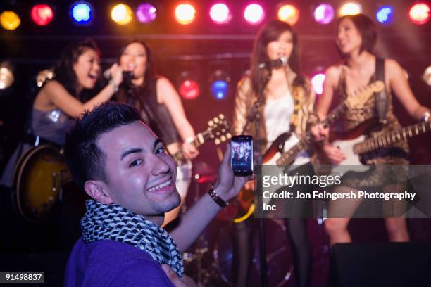 man video recording musical group onstage - rock singers stock pictures, royalty-free photos & images