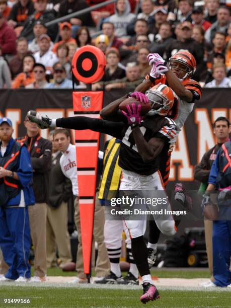 Wide receiver Mohamed Massaquoi of the Cleveland Browns catches a pass despite the effort of defensive back Leon Hall of the Cincinnati Bengals...