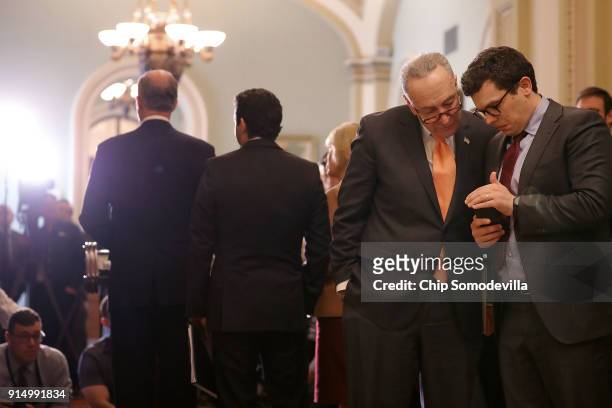 Senate Minority Leader Charles Schumer talks with his communications director Matt House during a news conference following the weekly policy...