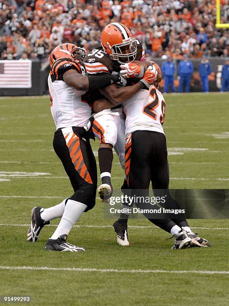 Running back Jerome Harrison of the Cleveland Browns is tackled by defensive backs Chinedum Ndukwe and Leon Hall of the Cincinnati Bengals during a...