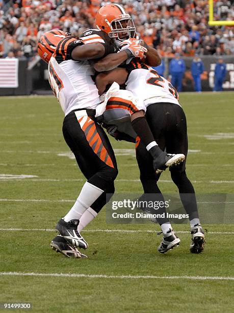 Running back Jerome Harrison of the Cleveland Browns is tackled by defensive backs Chinedum Ndukwe and Leon Hall of the Cincinnati Bengals during a...