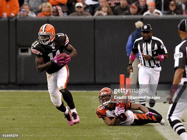 Wide receiver Mohamed Massaquoi of the Cleveland Browns runs upfield after catching a pass and avoiding the tackle of defensive back Leon Hall of the...