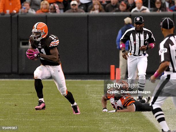 Wide receiver Mohamed Massaquoi of the Cleveland Browns runs upfield after catching a pass and avoiding the tackle of defensive back Leon Hall of the...