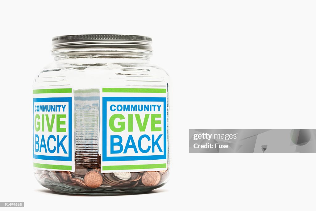 Jar of pennies with "community give back" sticker
