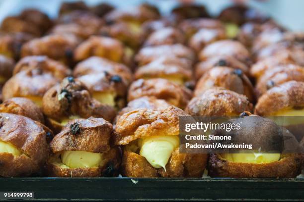 Frittelle, a typical sweet of Venetian carnival, filled with custard are seen on a tray in Costantini laboratory on February 6, 2018 in Venice,...