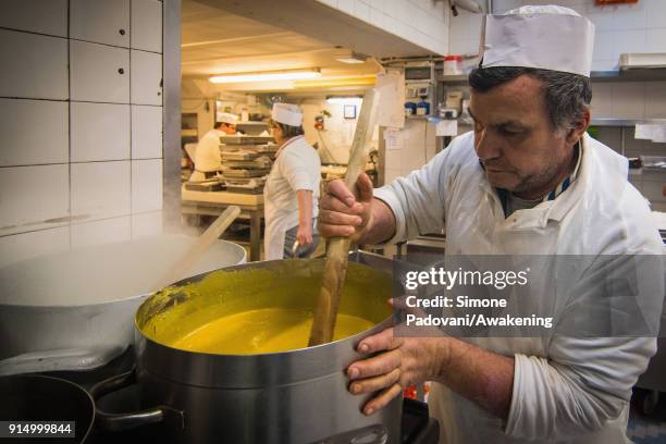Pastry chef prepares the custard for Frittelle, a typical sweet of Venetian carnival, in Rosa Salva laboratory on February 6, 2018 in Venice, Italy....