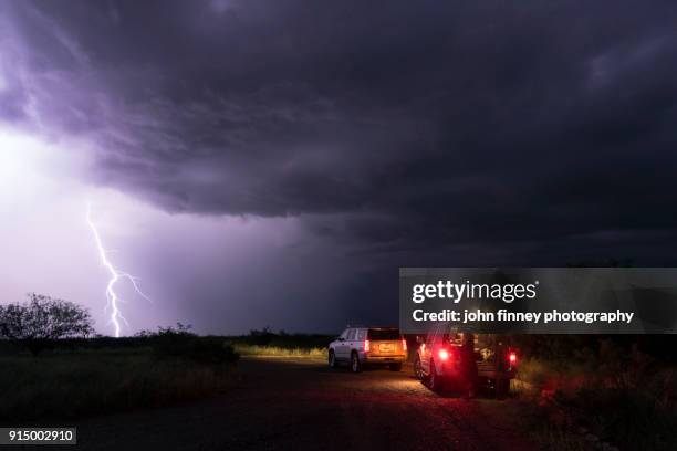 lightning bolt hits the ground with storm chasers watching, arizona, usa. - mammatus cloud stock pictures, royalty-free photos & images