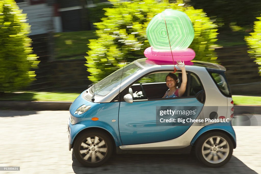 Woman with beach ball on smart car