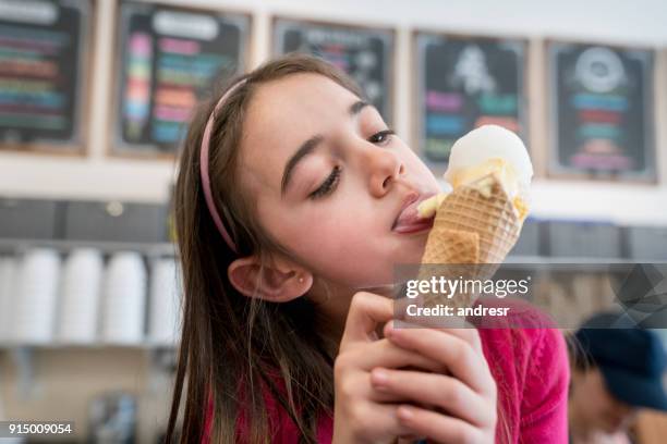 beautiful little girl enjoying a delicious ice cream cone licking it - girls licking girls stock pictures, royalty-free photos & images