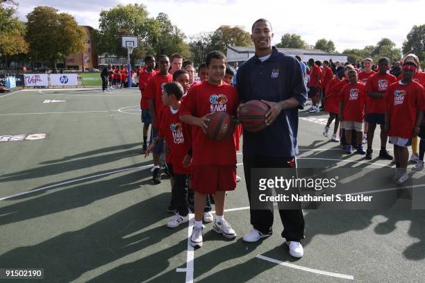 Derrick Rose of the Chicago Bulls poses with a kid at a NBA Cares Basketball Clinic during the 2009 NBA Europe Live on October 4, 2009 at Clapham...